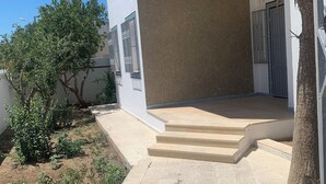 A modern building with a paved walkway leading to a set of stairs. - Villa Soliman Plage s+3 (Nabeul)