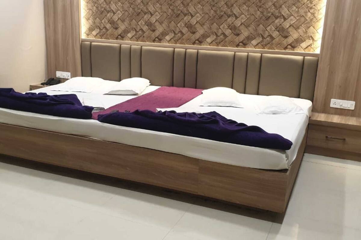 Una camera da letto moderna con una struttura letto in legno, una testiera con pannelli verticali e una parete dietro il letto con motivo a intreccio.