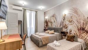 A hotel room with a bed, a desk, a chair, and a large wall mural. - Napolehome Luxury Apartment in the center of Rome (Roma)