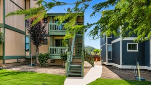 Ein Gebäude mit einer zentralen Treppe, einem kleinen Baum und blauem Himmel.