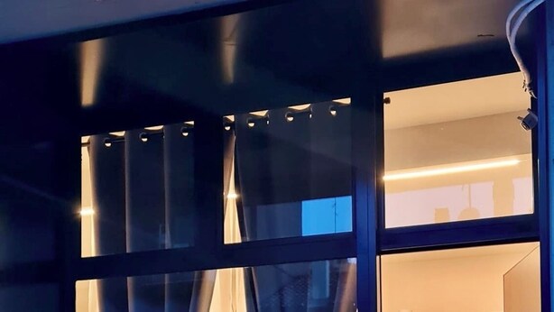 Uma cozinha moderna com armários brancos, micro-ondas e uma mesa de jantar com cadeiras.