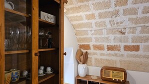 A wooden cabinet with glass doors containing various glassware and kitchen items. - Le Camerette in Monopoli (Monopoli)
