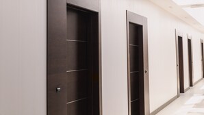 Un couloir bordé de portes, chacune dotée d’une poignée et d’un trou de serrure.