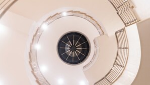 Un escalier en colimaçon doté d’un pilier central et de rampes.