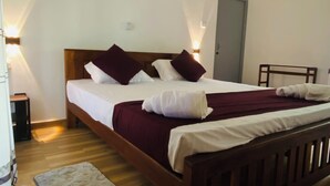 A bedroom with a wooden bed, a headboard, a bedside table, a nightstand, a floor lamp, and a ceiling fan. - River Paradise Safari House with Cooking Class (Udawalawa)