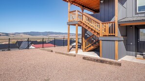 Ein modernes Gebäude mit einer Holzterrasse und einer Treppe, die zu einer zweiten Etage führt.