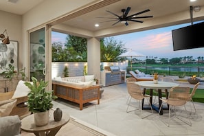 Eine Terrassensitzgelegenheit mit Essbereich und Grill.