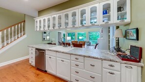 A kitchen with white cabinetry, a granite countertop, and a dishwasher. - Alpine Chalet| 5BR | Helen, GA| near golf| community pool (Helen)
