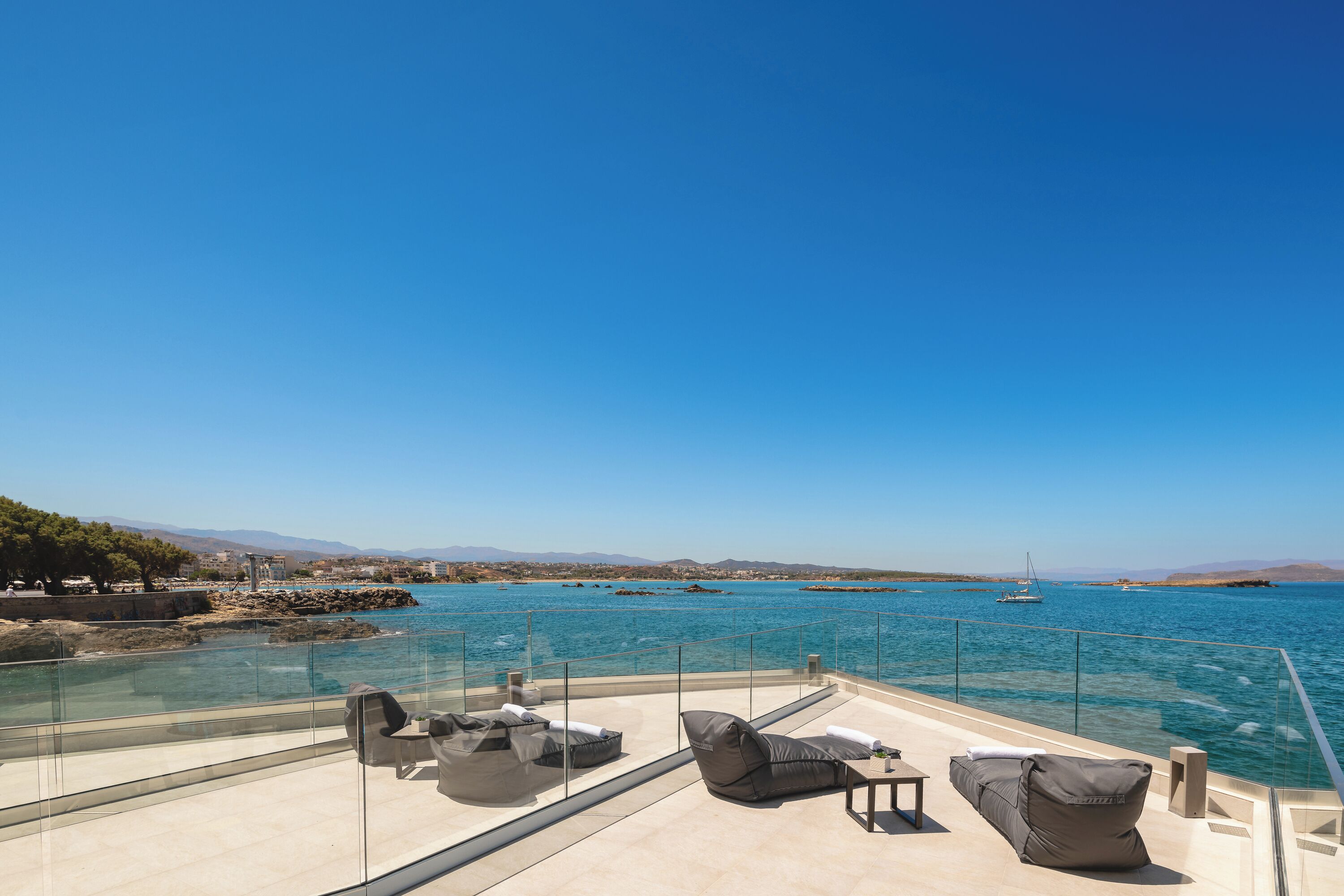 A terrace with outdoor seating and a view of the sea.