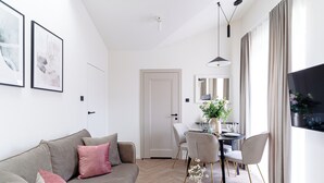 A modern living room with a sofa, chairs, a dining table, and artwork on the walls. - Miodova20 by StayLab (Kraków)
