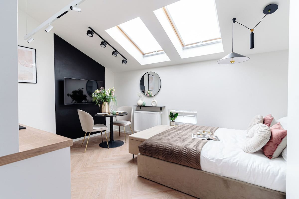 Un dormitorio moderno con tragaluces, una cama, un escritorio y una silla.