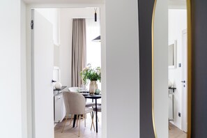 Un coin repas moderne avec une table dressée pour deux personnes, une chaise et un vase de fleurs.