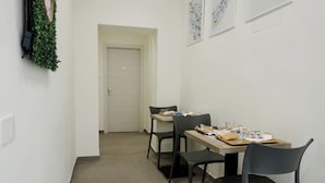 Egy étkező, ahol egy két személyre megterített asztal, két szék és a háttérben egy ajtó látható.