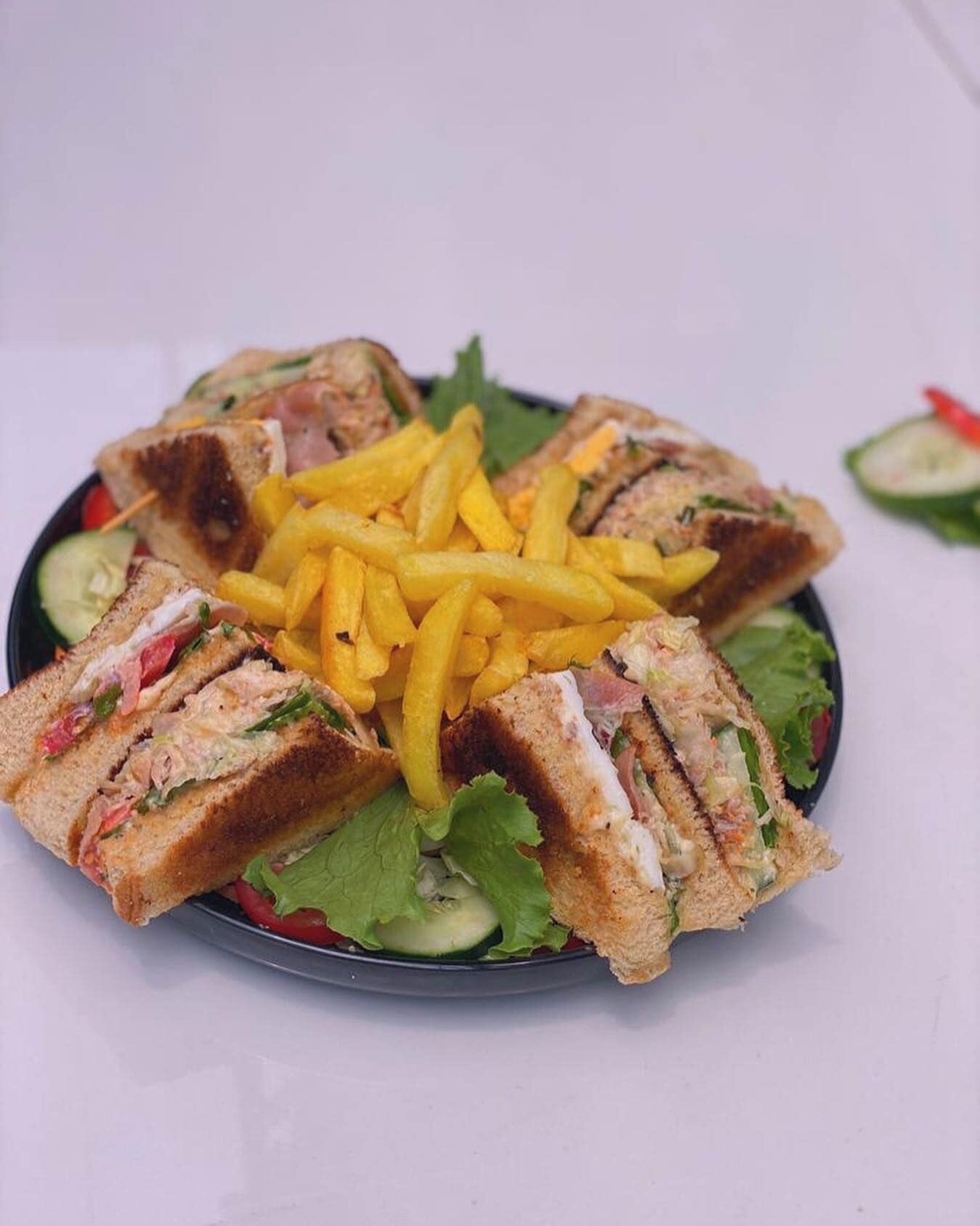 A plate of sandwiches with french fries and a salad.