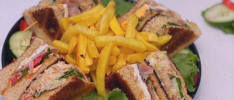 A plate of sandwiches with french fries and a salad.