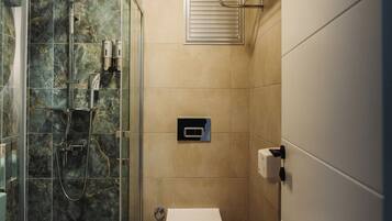 A bathroom with a glass-enclosed shower, a toilet, and a towel rack.