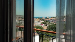 Varanda com vista para uma cidade costeira, incluindo edifícios e o mar.