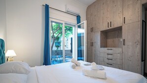 Une chambre d’hôtel avec un lit, une table de chevet avec une lampe, une armoire et une vue sur l’extérieur.