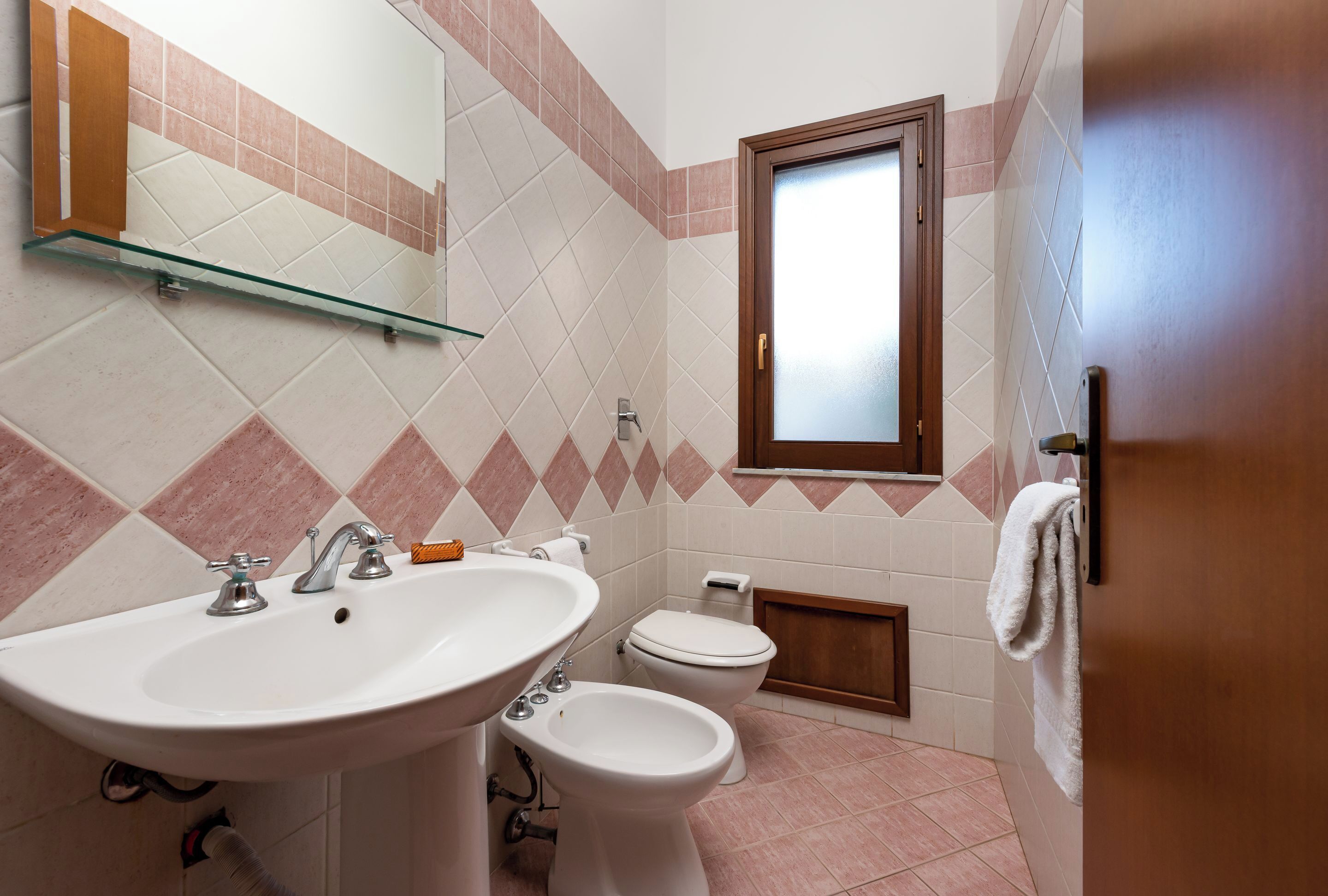 Une salle de bain équipée d’un lavabo, d’un bidet, de toilettes et d’une fenêtre.