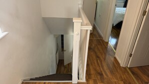 Un escalier avec une rampe en bois et une plateforme recouverte de moquette.