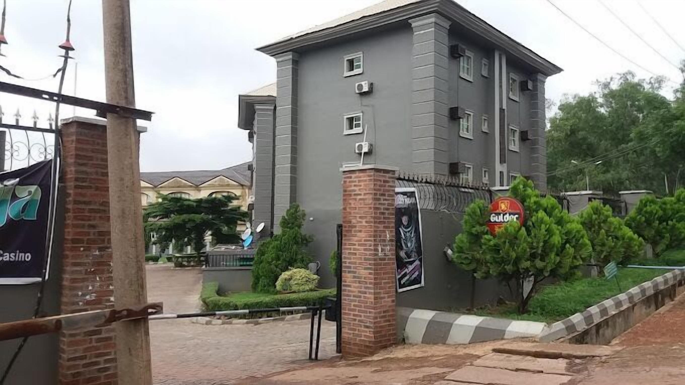 Un edificio de varios pisos con base de ladrillo y pisos superiores grises. Se observan unidades de aire acondicionado en las paredes exteriores.