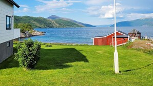 Ein modernes Haus mit Blick auf einen See und Berge.