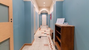 A hallway with directional arrows on the floor, a wooden reception desk, and a 'No Smoking' sign. - Italianway Comfort - Gessi 49 (Milan)