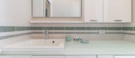 A bathroom with a white sink, a mirror, and a tiled backsplash.