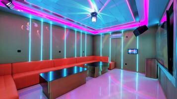 A modern lounge with a red sofa, a metallic coffee table, and a ceiling with neon lighting.