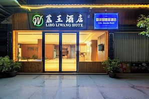 Das äußere Erscheinungsbild des Libo Liwang Hotels mit einem deutlichen Eingang, Beschilderung und Pflanzgefäßen.