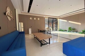 Een modern interieur met een blauwe bank, een houten tafel en een eethoek.