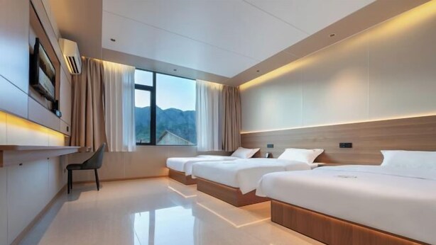 Una habitación de hotel moderna con una cama grande, un escritorio y una silla.