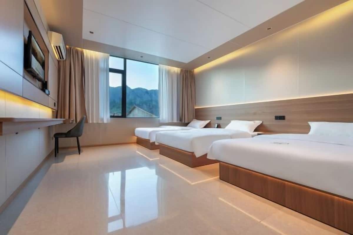 Una habitación de hotel moderna con una cama grande, un escritorio y una silla.