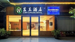 Exterior del Hotel Libo Liwang con fachada de madera, un amplio acceso de vidrio y señalización en inglés y chino.