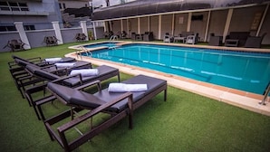 A swimming pool with lounge chairs and a covered area. - Elegant Hotel by Best Western Plus  (Enugu)