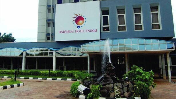 A hotel with a large sign reading "UNIVERSAL HOTEL ENUGU" and a water feature in front. - Universal Hotel Enugu (Enugu)