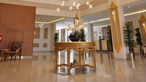 A spacious lobby with a high ceiling, ornate chandeliers, and a reception desk. - alzuwain hotil (Arar)
