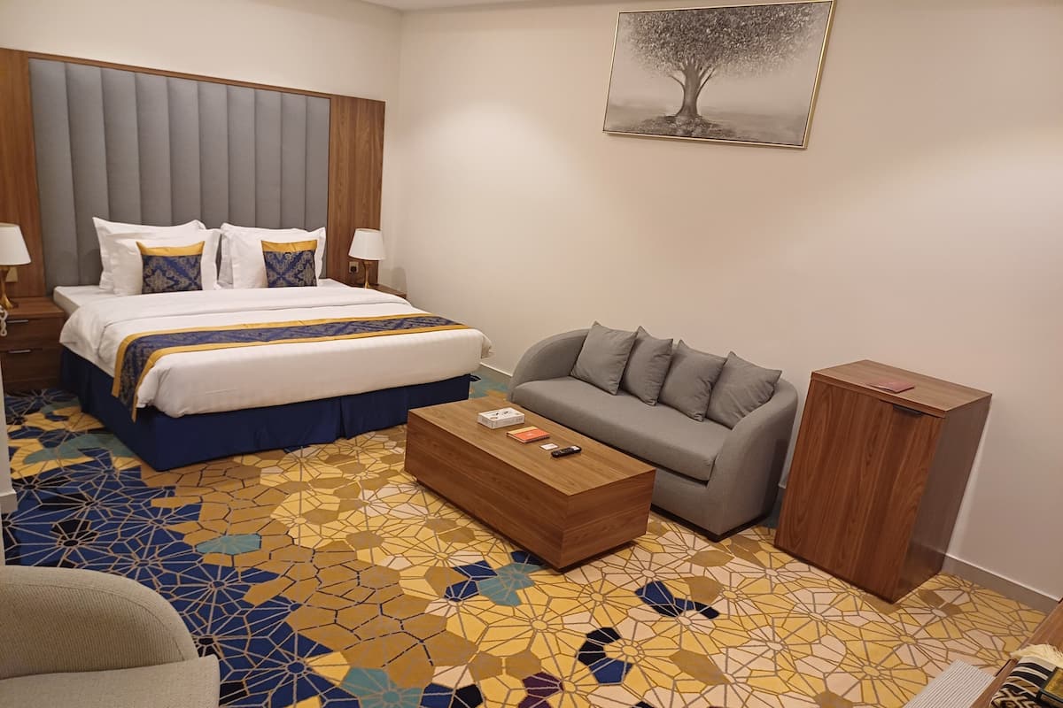Ein Hotelzimmer mit einem Bett, einer Couch, einem Couchtisch und einem Schrank.