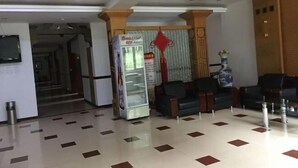 A lobby with a vending machine, seating area, and a television mounted on the wall. - Jingpo Lake Mountain villa hotel (Ning'an)