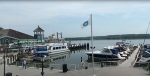 A marina with docked boats, a flag, and a building with a tower.