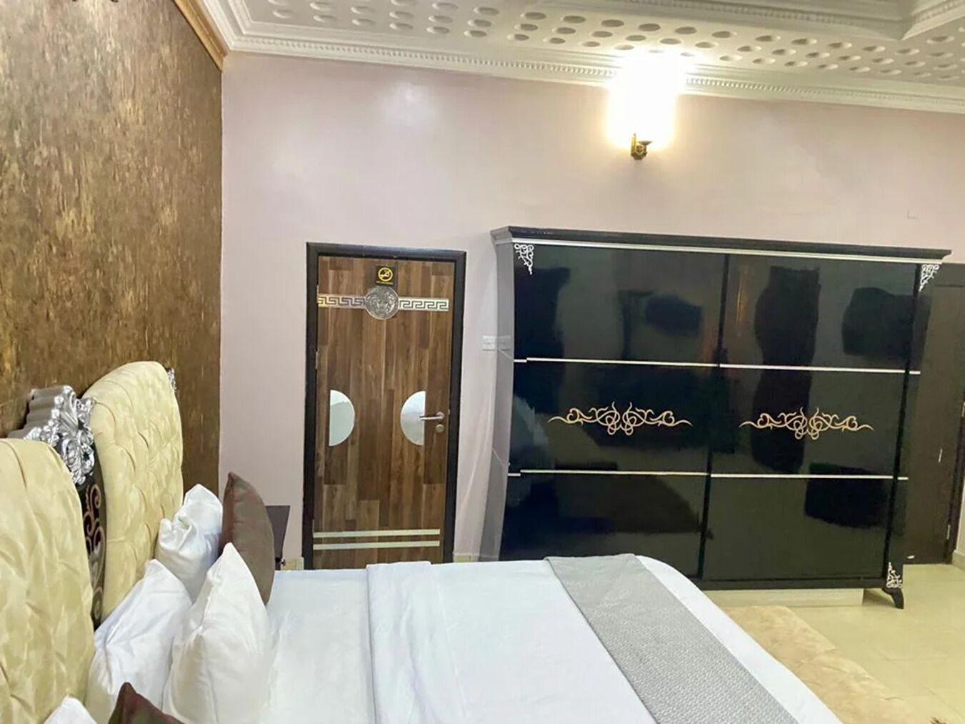 A bedroom with a bed, a wardrobe, and a door.