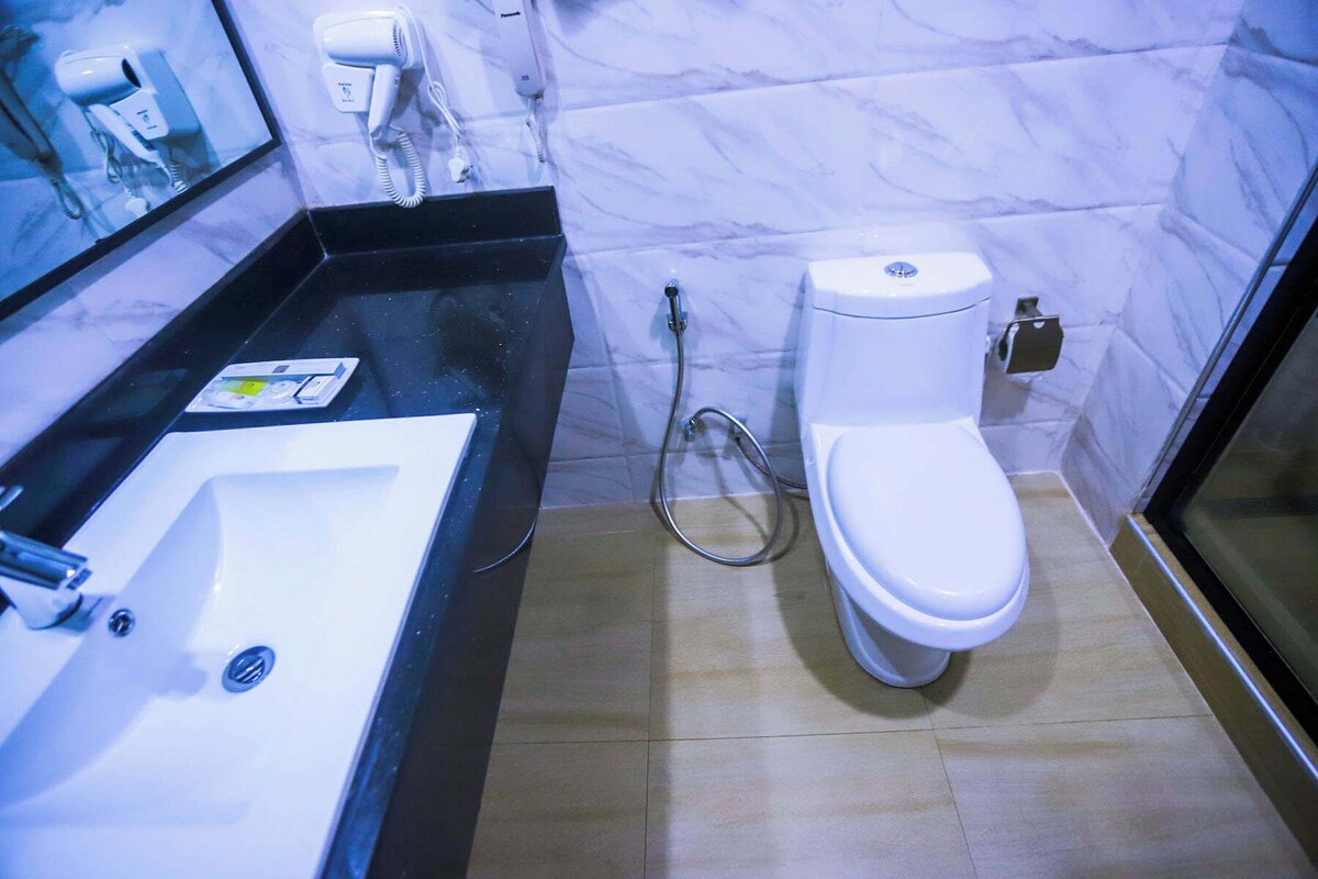 A bathroom with a white sink, a toilet, and a shower.