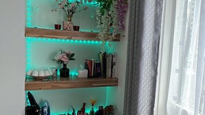 A shelf with decorative items, books, and a vase with flowers. - Cosy London Apartment Near Borough Market (London)
