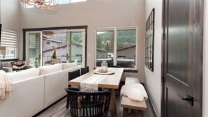 A modern kitchen with a large island, seating area, and large windows offering views of the surrounding area.