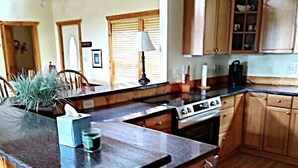 A kitchen with wooden cabinets, a granite countertop, and a built-in stove.