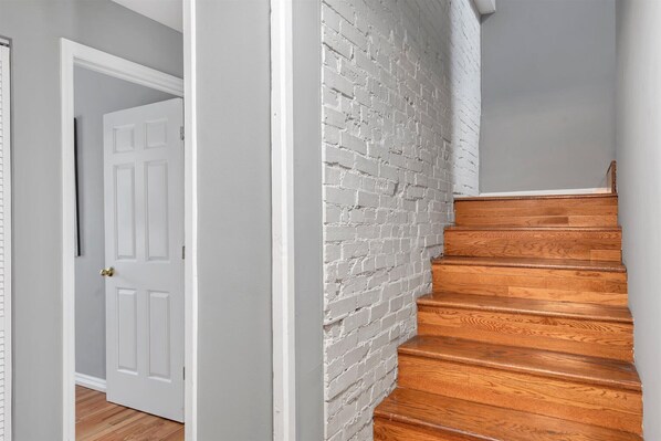 A staircase with wooden steps and a white brick wall.
