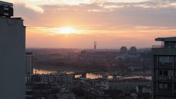 A cityscape with a river, a bridge, and buildings during sunset.