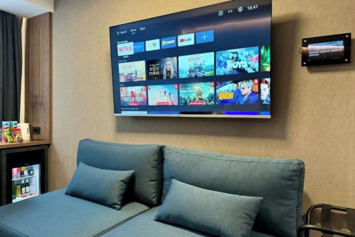 A modern living room with a large flat-screen TV displaying various streaming services.