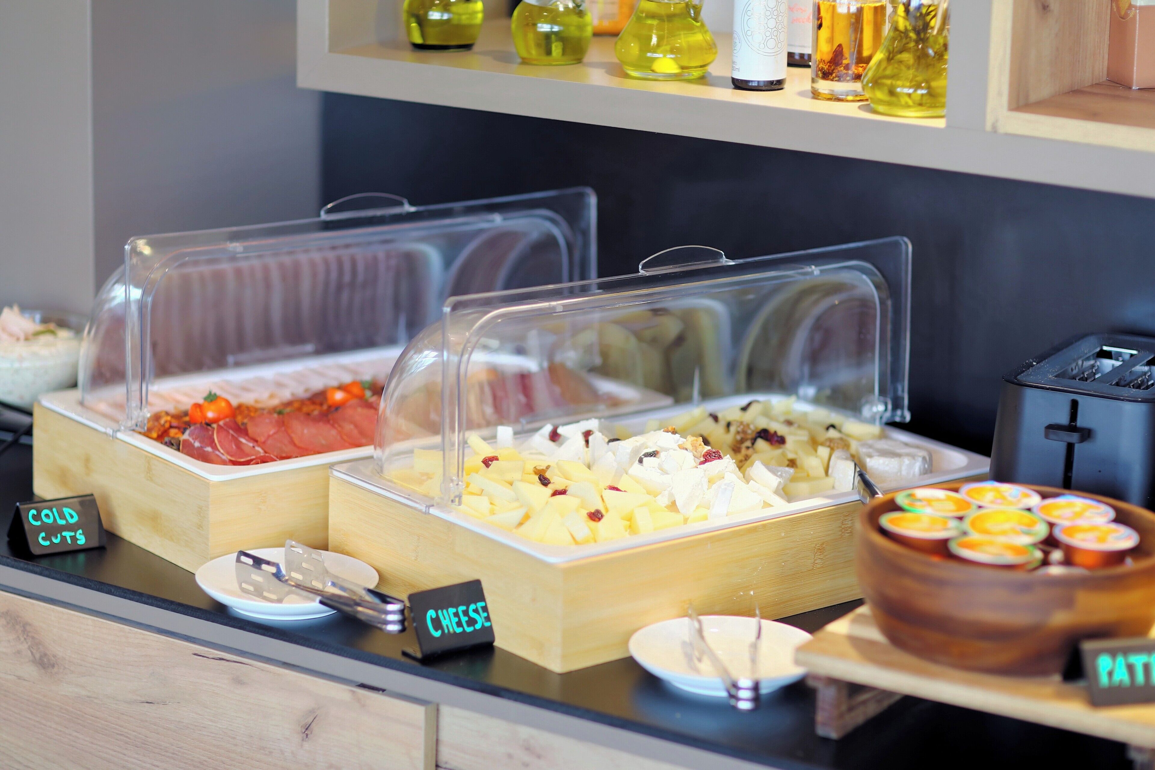 Un buffet avec des présentoirs clairement identifiés pour les charcuteries, les fromages et les pâtés.