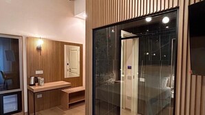 A modern bathroom with a wooden vanity, a bench, and a glass shower enclosure. - Heraklean Suites Tropea (Tropea)